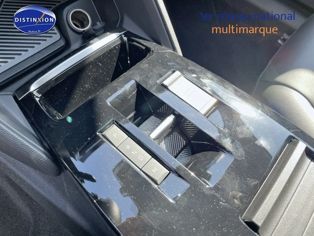 Gros plan sur la console centrale noire brillante de la Citroën C4 2024 avec commandes de boîte automatique.