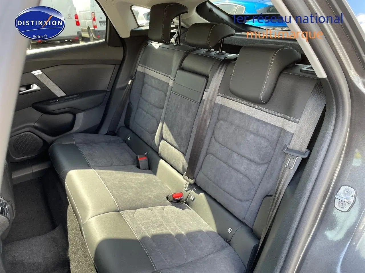 Vue intérieure arrière montrant les sièges arrière en cuir noir et tissu gris d'une Citroën C4 gris platinium 2024.