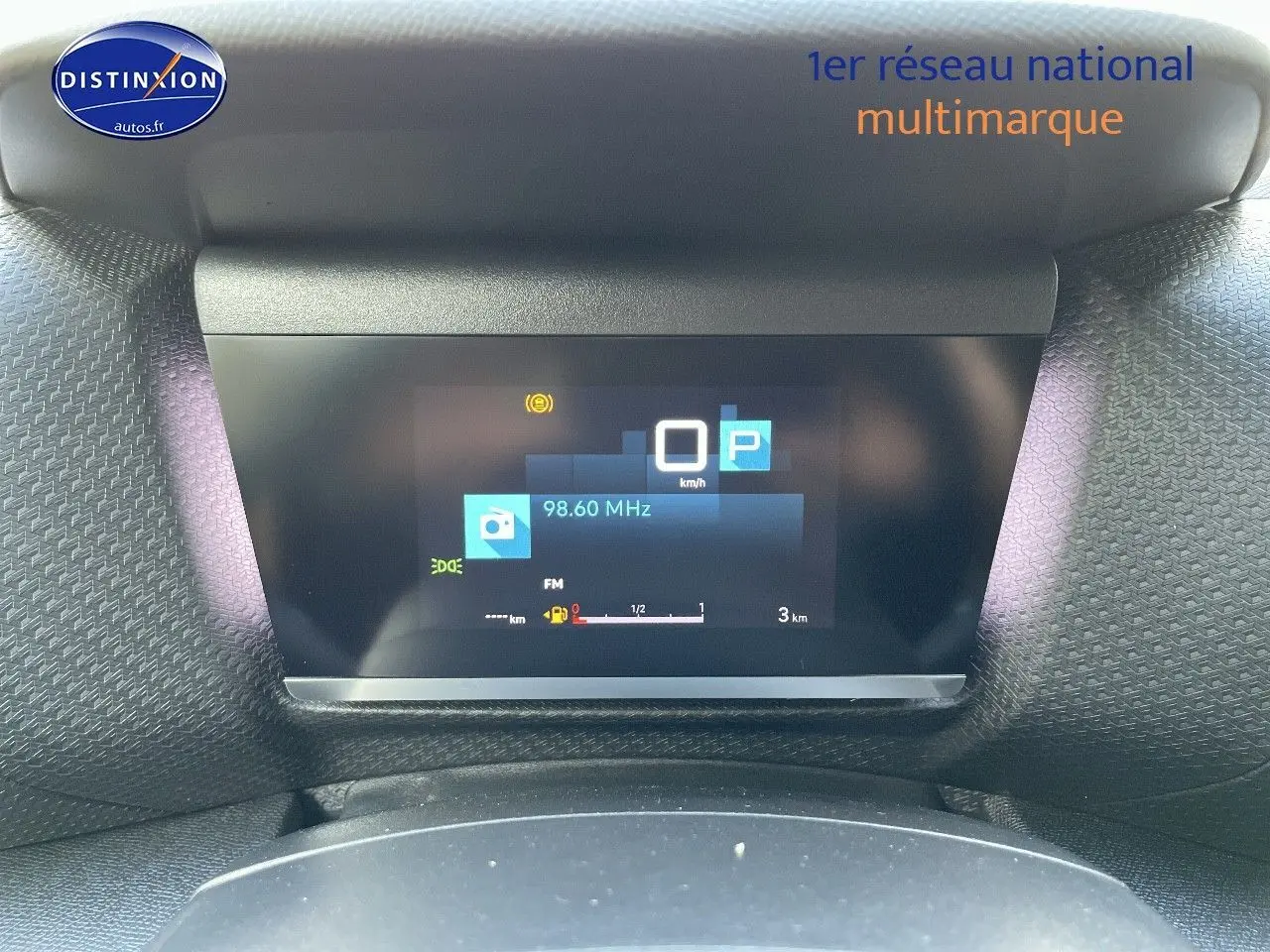 Affichage numérique du tableau de bord de la Citroën C4 gris platinium, montrant la vitesse à 0 km/h et la radio FM.