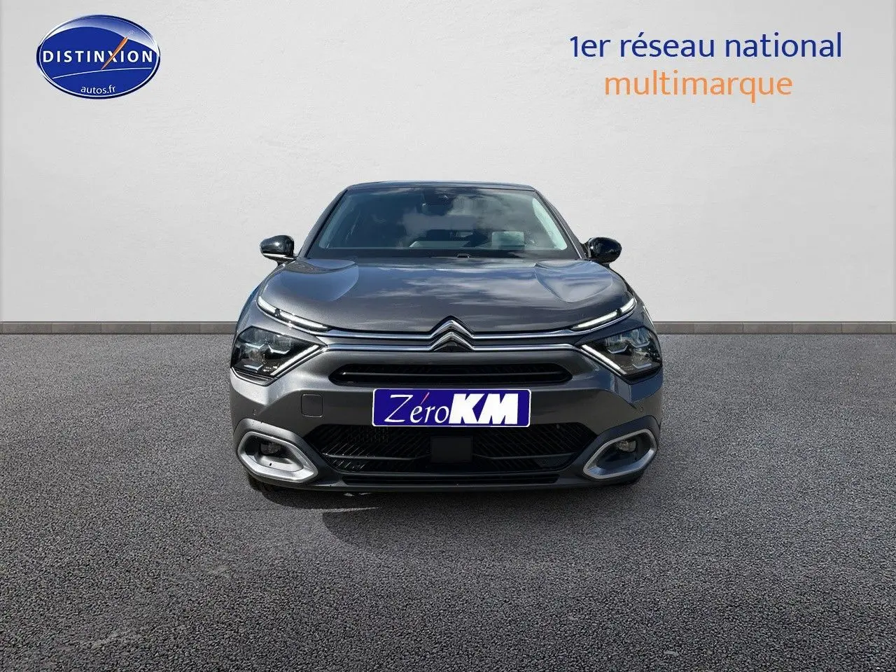 Vue frontale d'une Citroën C4 2024 gris platinium métal avec calandre distinctive et feux LED modernes.