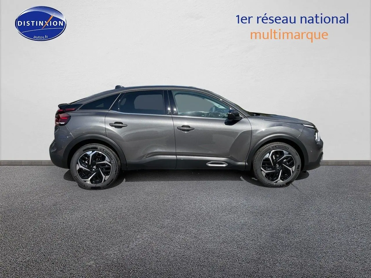 Profil côté gauche d'une Citroën C4 gris platinium métal 2024 avec jantes noires et toit noir contrasté.