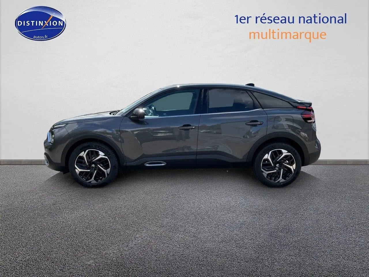 Profil droit d'une Citroën C4 2024 gris platinium métal avec jantes bicolores et toit noir contrasté.