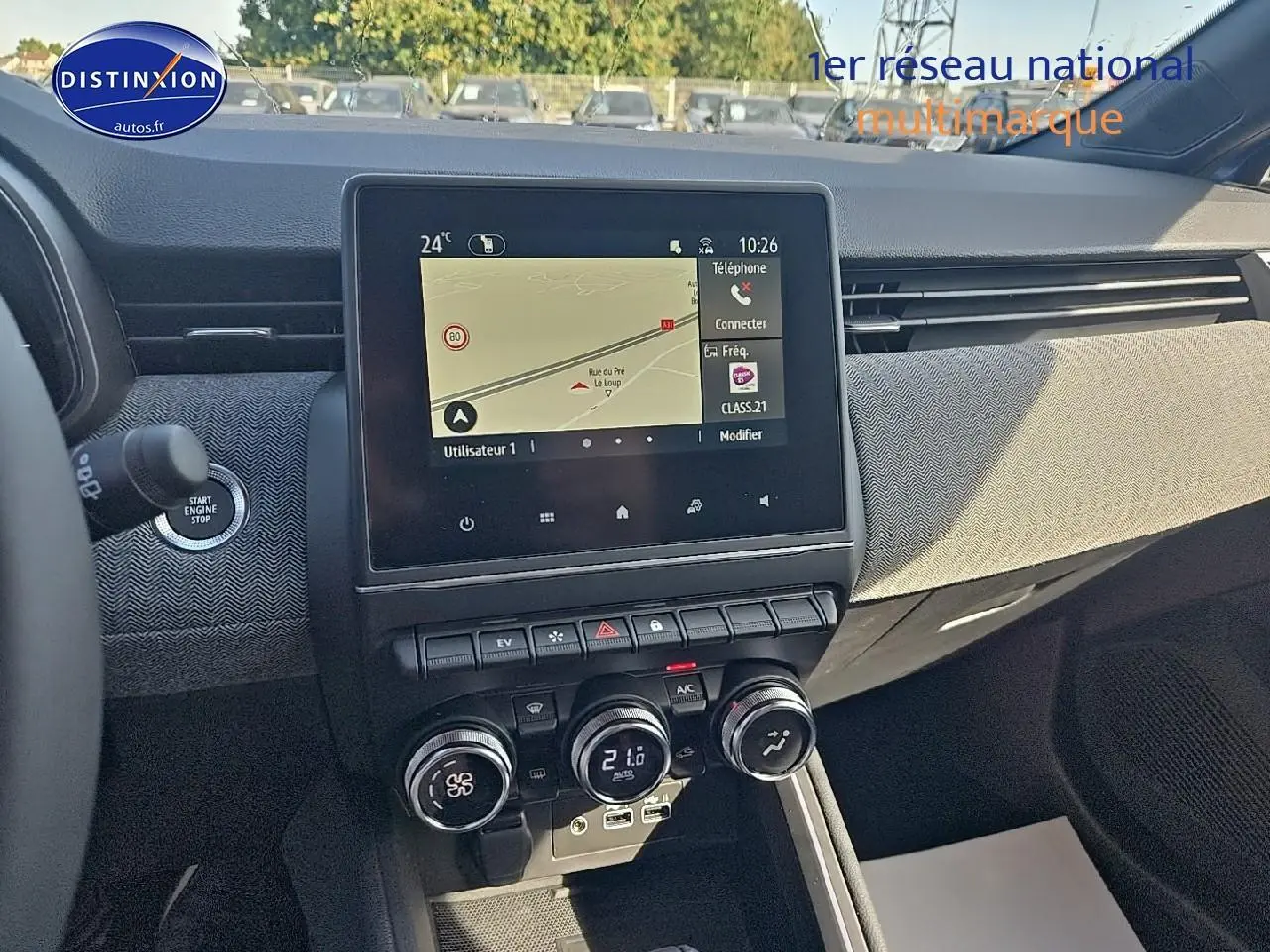 Tableau de bord de Renault Clio V bleu iron 2025, vue centrale sur écran tactile et commandes climatisation.