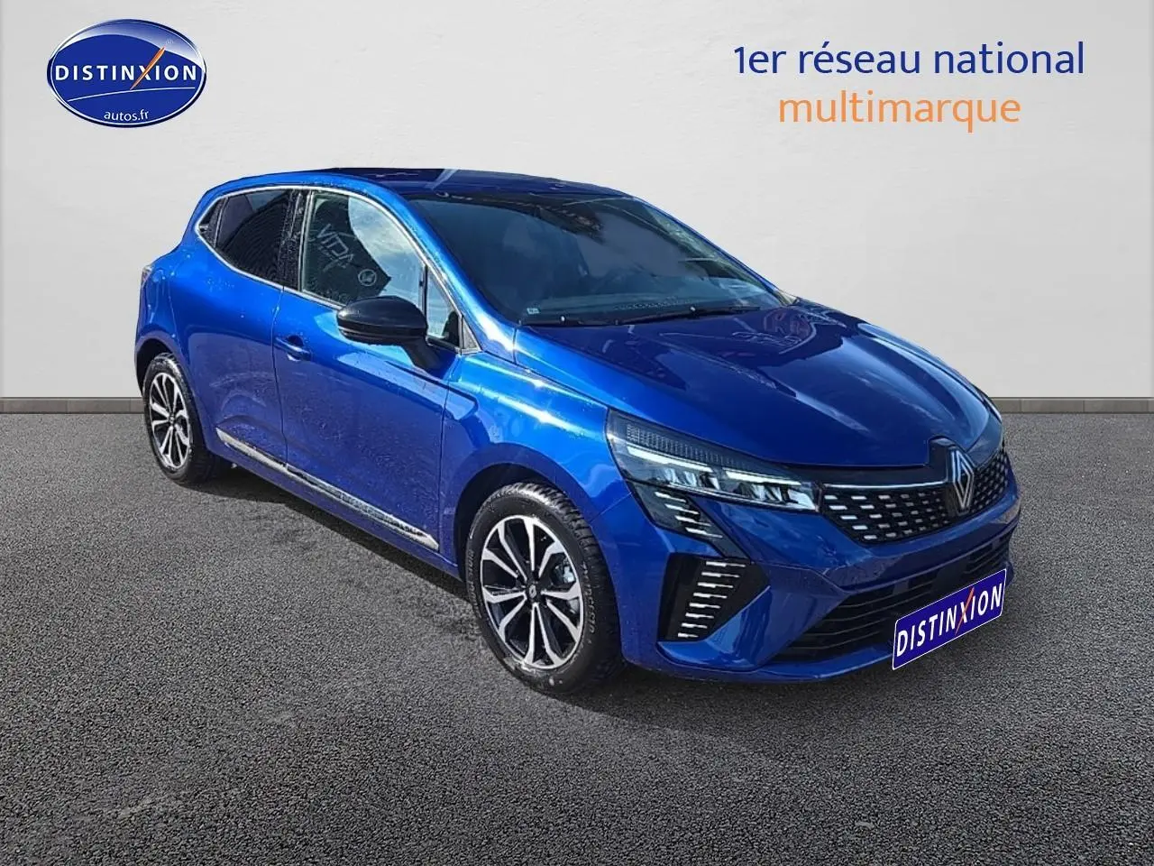 Renault Clio V 1.6 e-tech 145 techno bleu iron vue 3/4 avant avec calandre chromée et jantes alu noires.