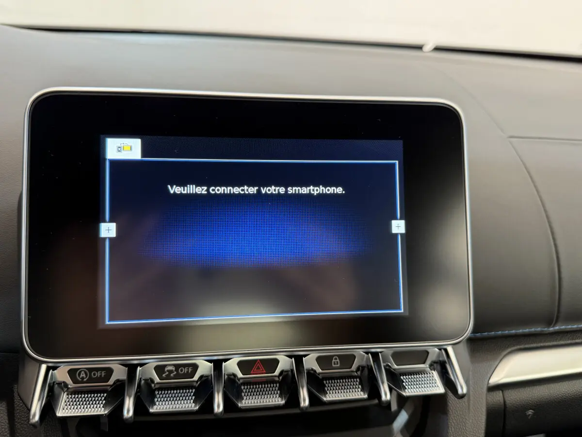 Écran tactile central affichant "Veuillez connecter votre smartphone" dans l'habitacle noir d'une Alpine A110 Légende 2019.