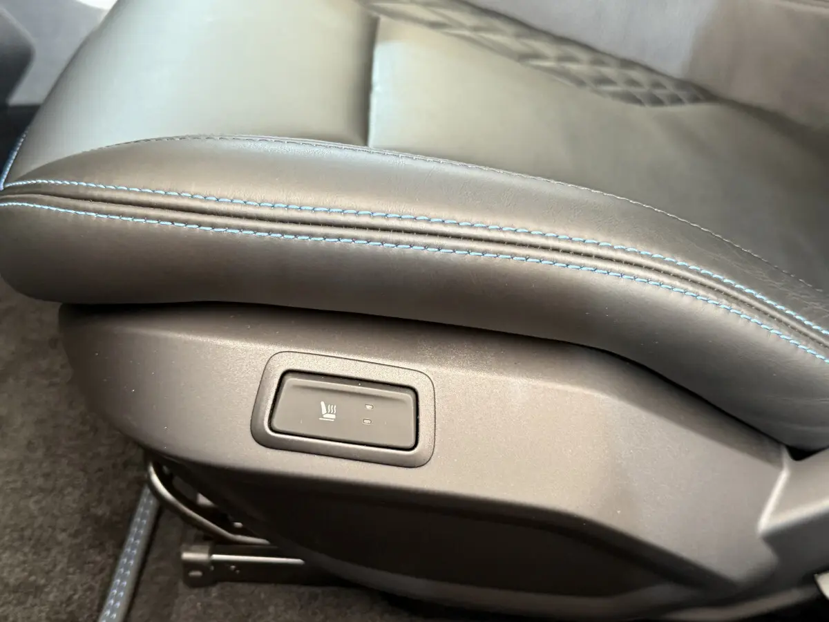 Gros plan sur le bouton de chauffage intégré au siège en cuir bleu de l'Alpine A110 Légende 2019.