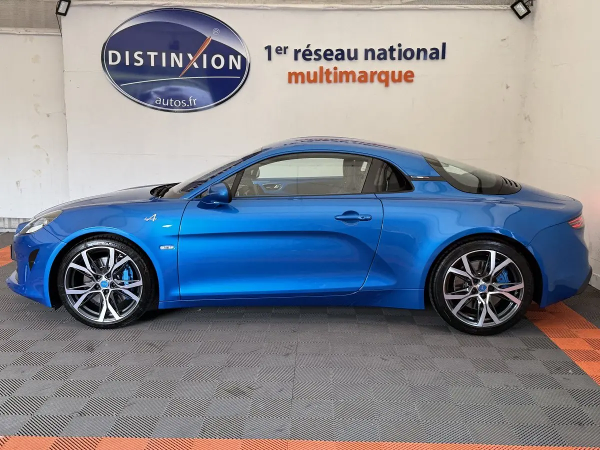 Profil côté gauche d'une Alpine A110 Légende bleu 2019, avec jantes sport et logo distinctif sur l'aile avant.