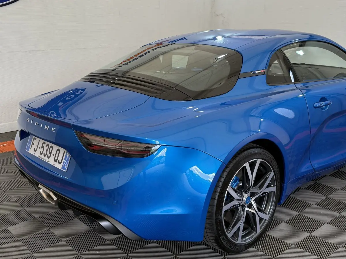 Vue 3/4 arrière droite d'une Alpine A110 Légende bleu brillant avec feux arrière LED et jantes alliage distinctives.