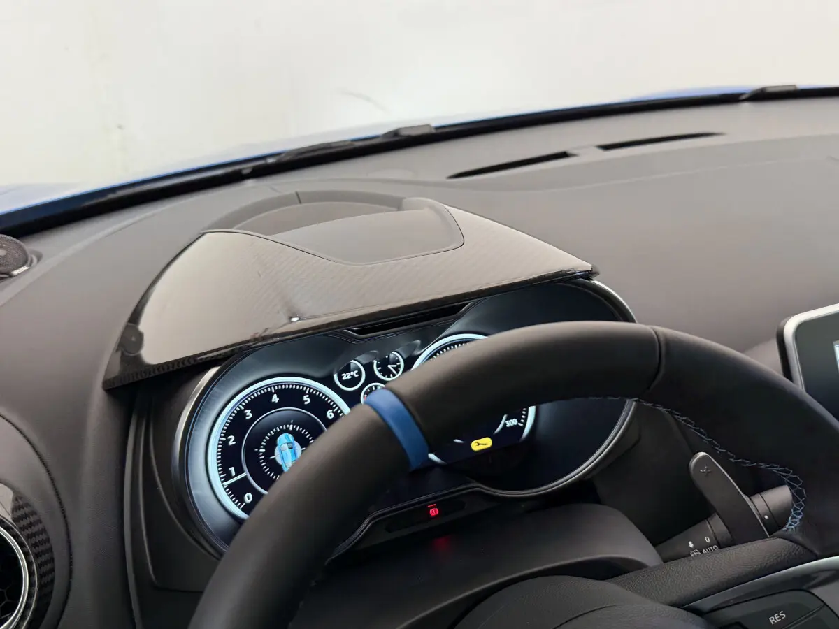 Tableau de bord et compteurs numériques de l'Alpine A110 Legende 2019 vus côté conducteur, volant cuir noir avec bande bleue.