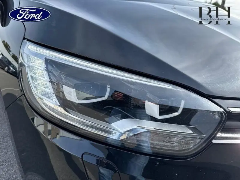 Gros plan sur le phare avant droit noir étoilé du Renault Grand Scenic 2017, soulignant son design moderne et précis.