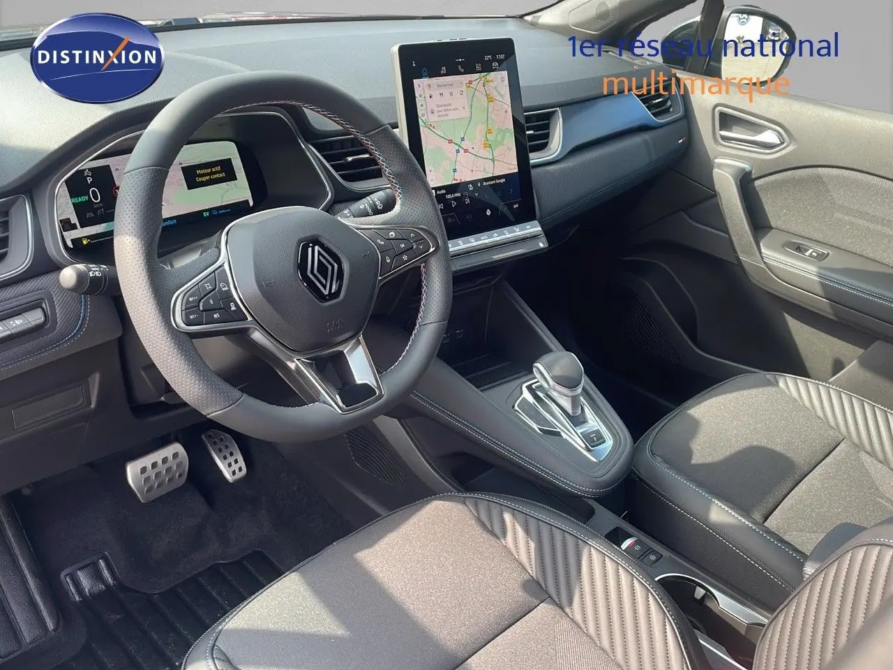 Intérieur du Renault Captur E-Tech hybride 2025 vu côté passager, tableau de bord noir avec écran tactile et sièges bi-matière.