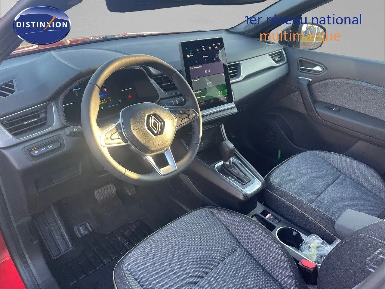 Vue intérieure avant droite du Renault Captur E-Tech hybride 2025, avec tableau de bord numérique et sellerie tissu gris.