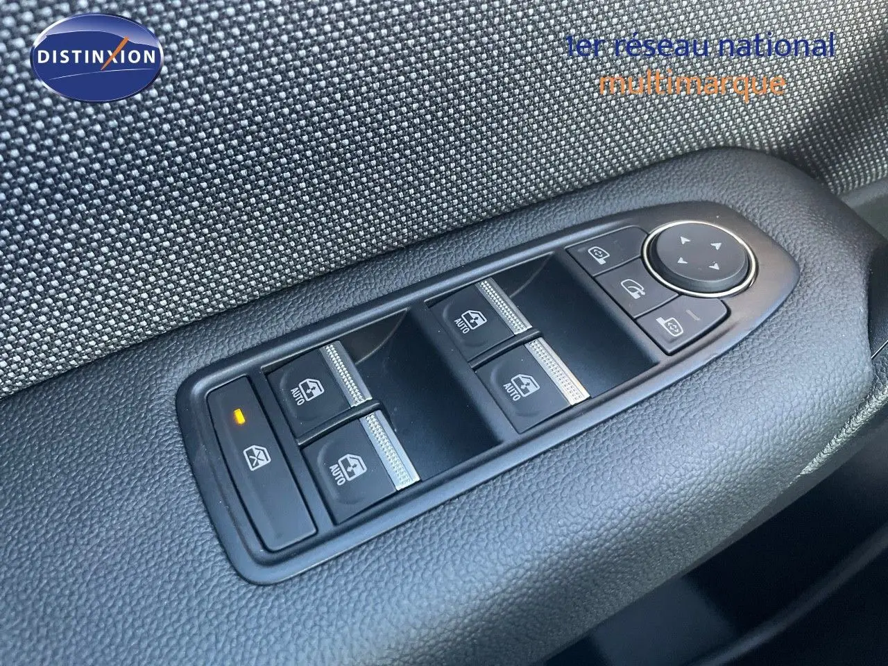 Gros plan sur les commandes de lève-vitres et rétroviseurs côté conducteur du Renault Captur rouge passion toit noir.