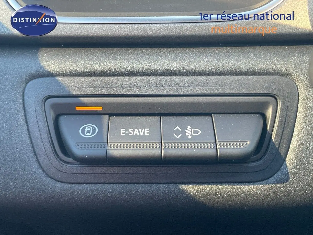 Gros plan sur les boutons de commande E-SAVE et réglage des phares du Renault Captur rouge passion 2025.