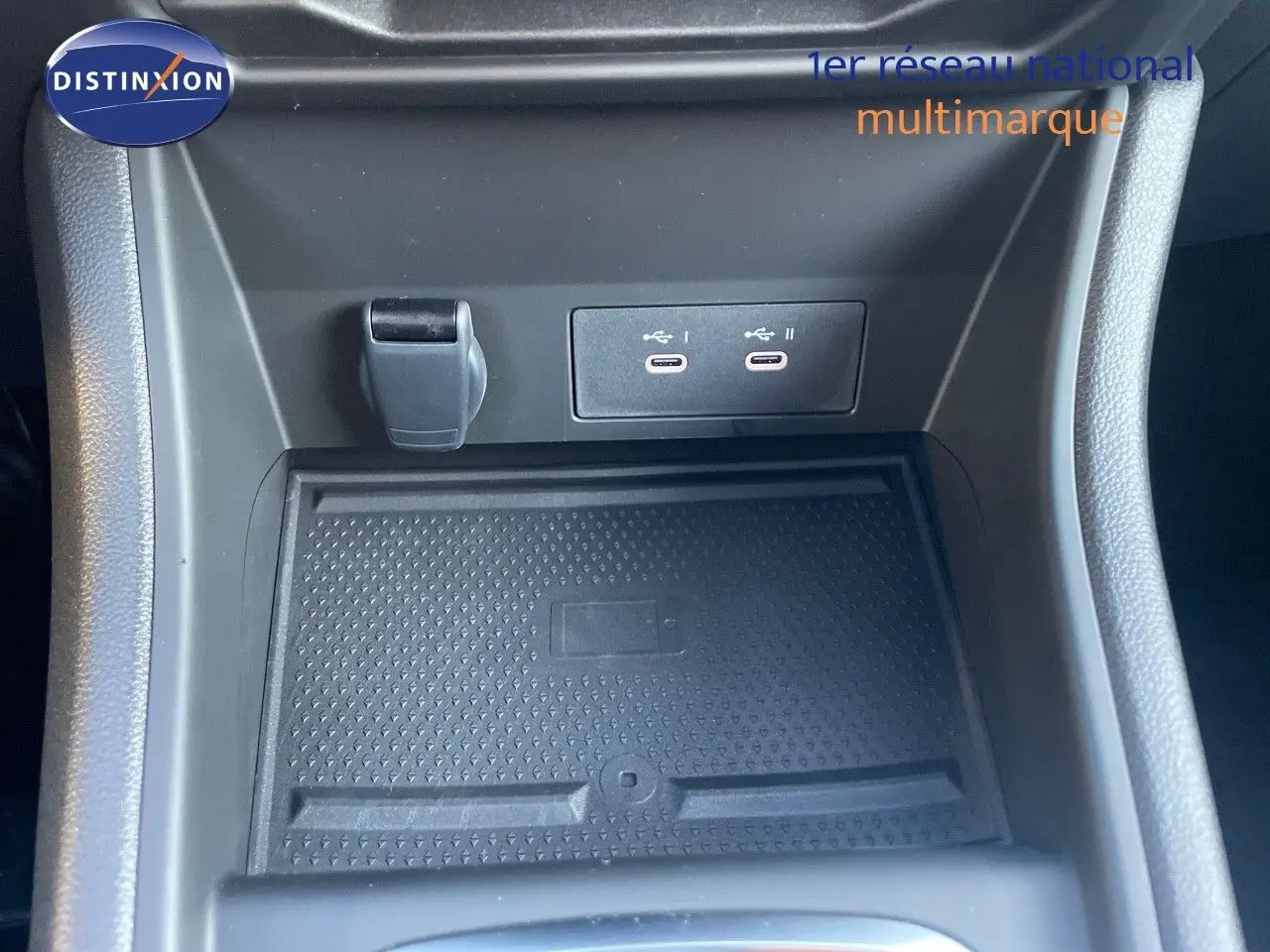 Détail de la console centrale avec prise USB double et zone de recharge sans fil du Renault Captur E-Tech hybride 2025.