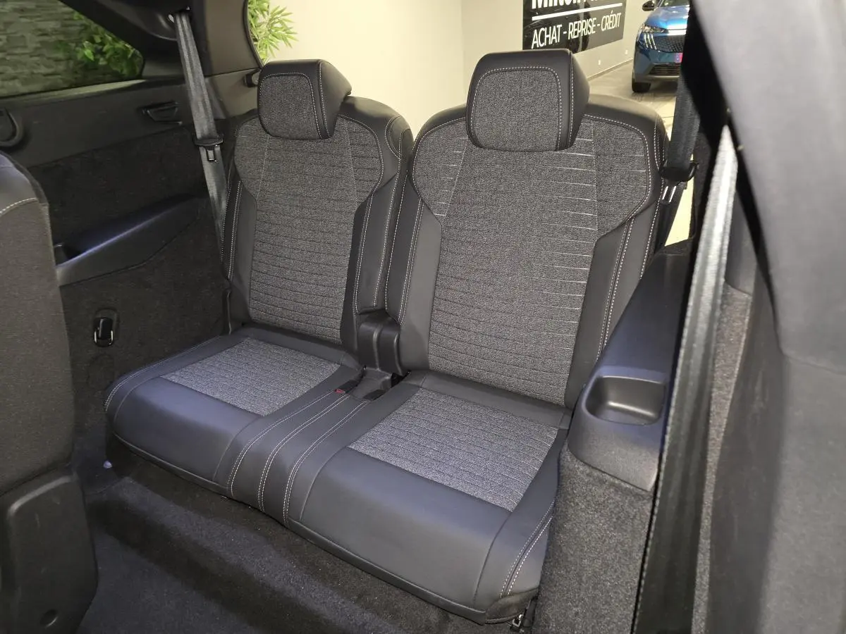 Vue intérieure rapprochée des deux sièges arrière en tissu gris et cuir noir du Peugeot 5008 blanc 2025.