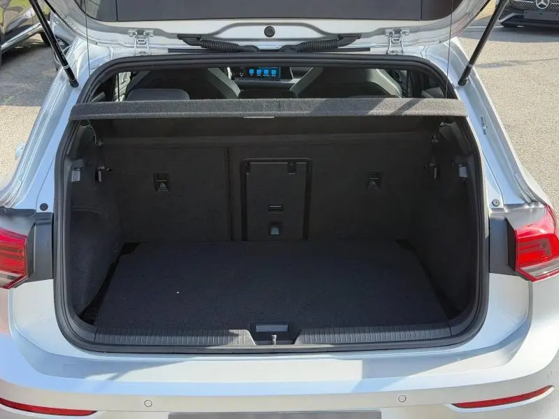 Coffre ouvert vu de l'arrière d'une Volkswagen Golf 1.5 eTSI R-Line 2024 en Reflet d'Argent métallisé, intérieur noir.