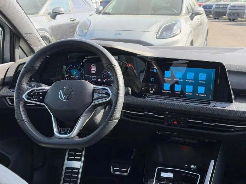 Vue intérieure centrée sur le volant multifonction et l'écran tactile de la Volkswagen Golf 1.5 eTSI R-Line 2024.