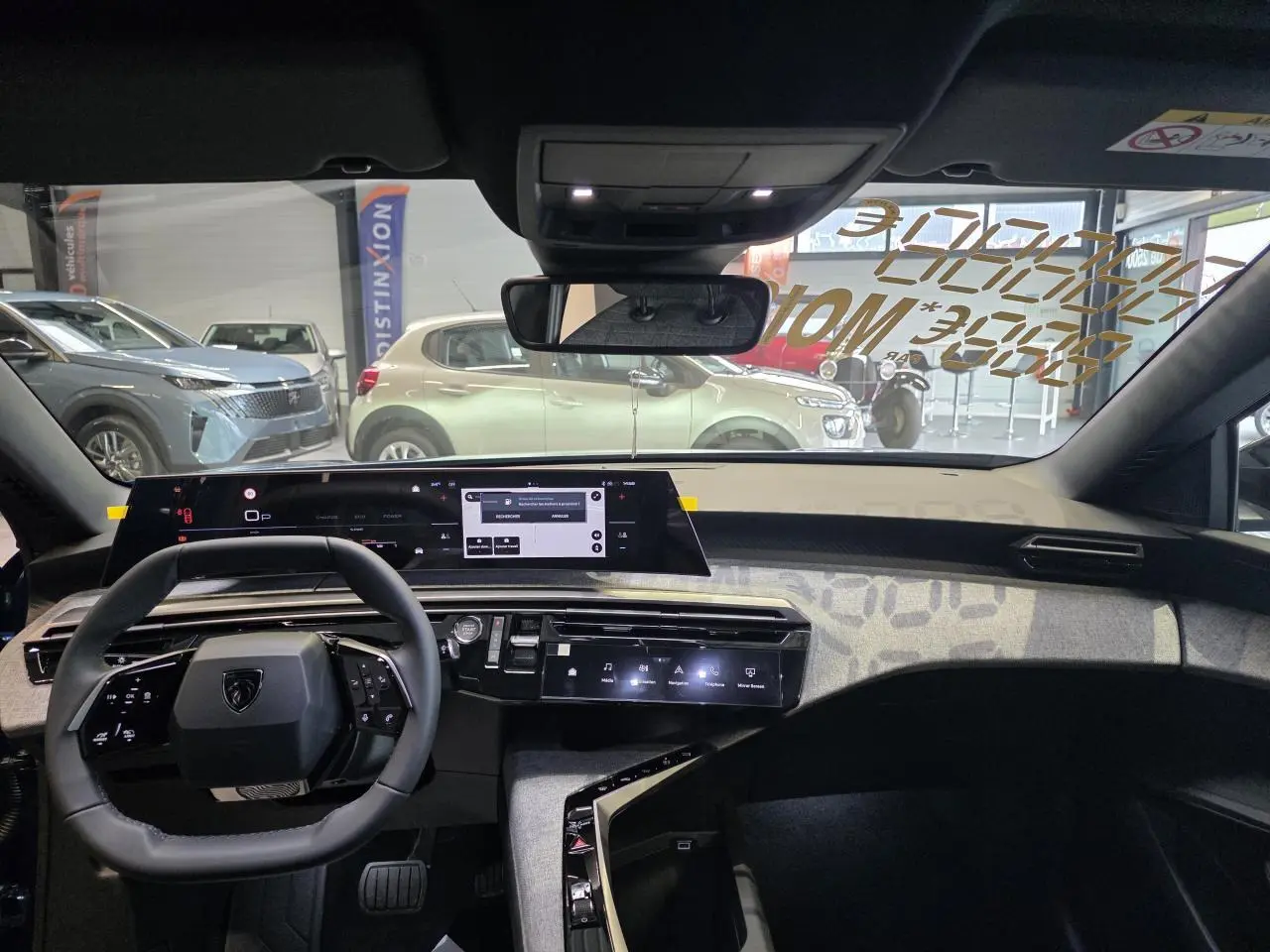 Vue intérieure avant du Peugeot 3008 bleu, tableau de bord avec écran panoramique et volant compact noir.