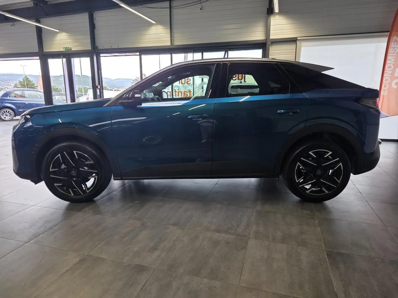 Peugeot 3008 bleu métallisé vue de profil côté gauche en intérieur avec jantes alliage noires.