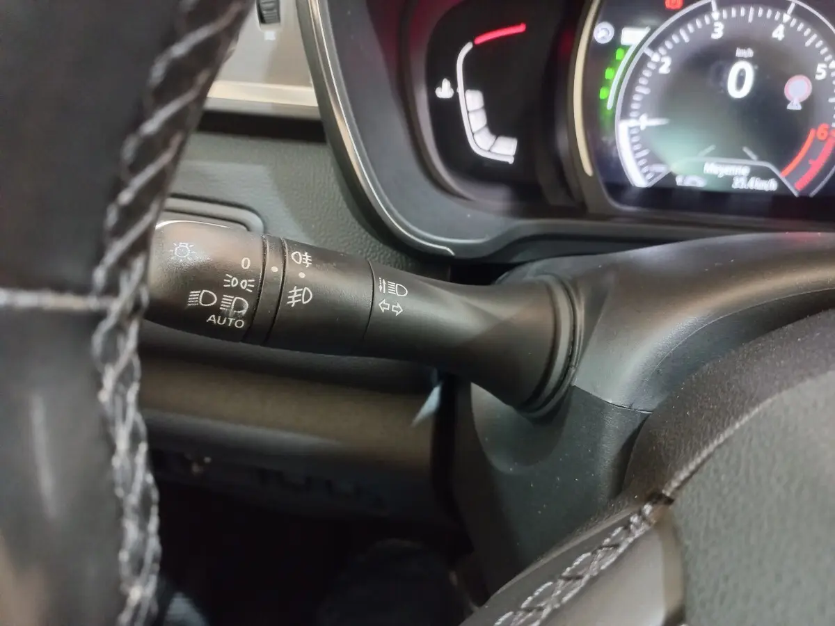 Gros plan sur la manette de commande des phares et clignotants du tableau de bord noir du Renault Kadjar Intens 2018.
