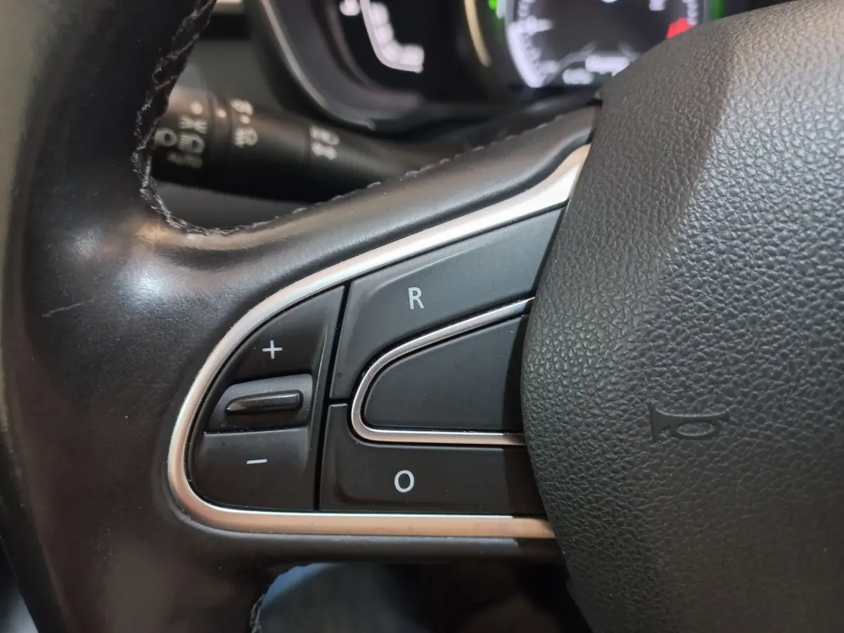 Gros plan sur les commandes de régulateur de vitesse au volant cuir noir du Renault Kadjar Intens 2018.