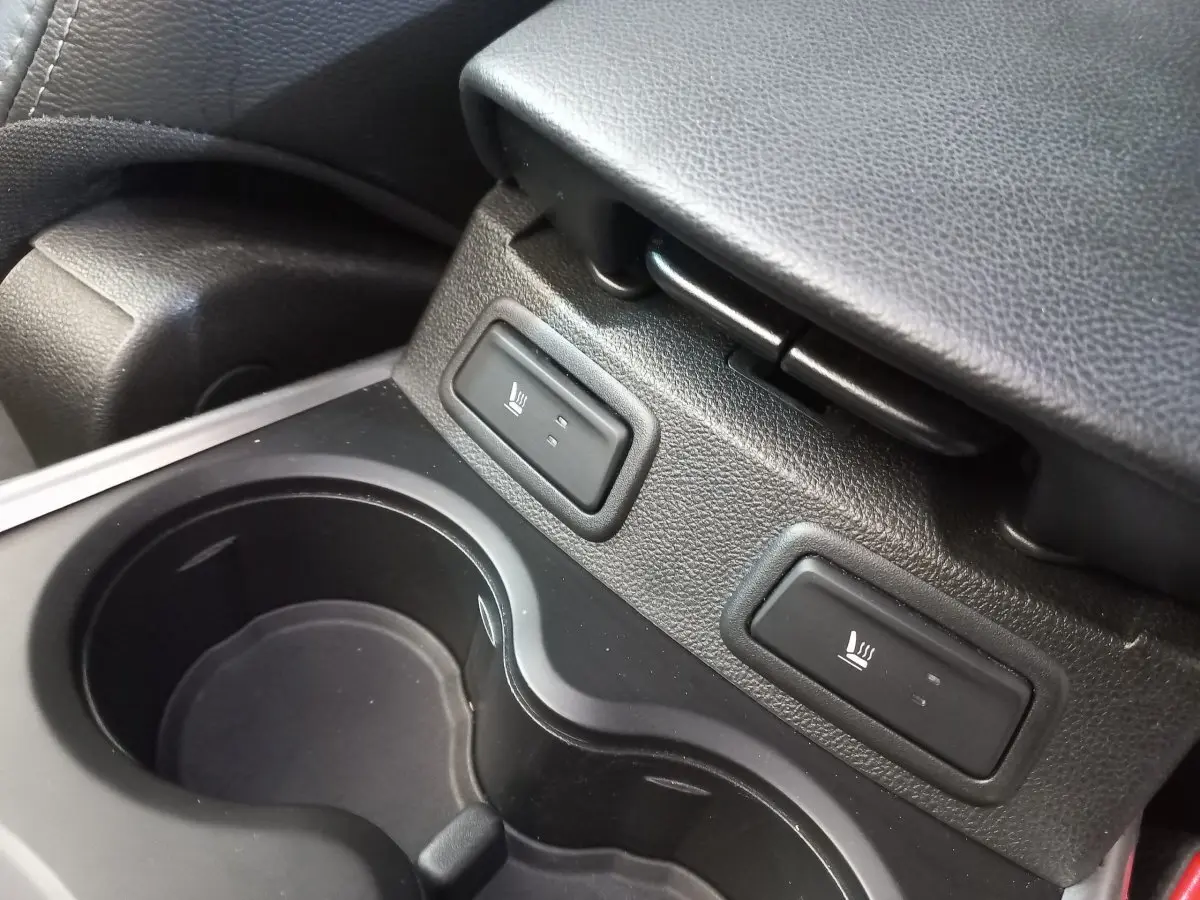 Gros plan sur les commandes de sièges chauffants et porte-gobelets noirs dans l'habitacle du Renault Kadjar Intens 2018.