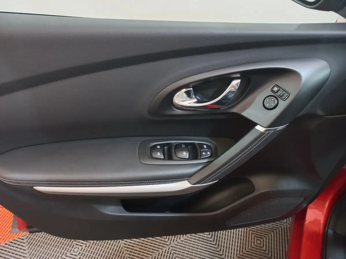 Détail de la porte avant gauche noire du Renault Kadjar 2018 avec commandes électriques et poignée chromée.