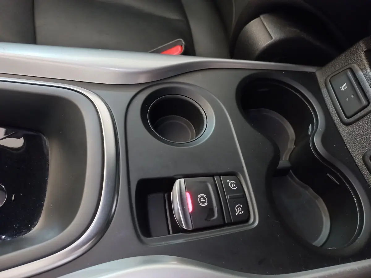 Vue rapprochée de la console centrale noire du Renault Kadjar Intens avec bouton frein à main électrique allumé.