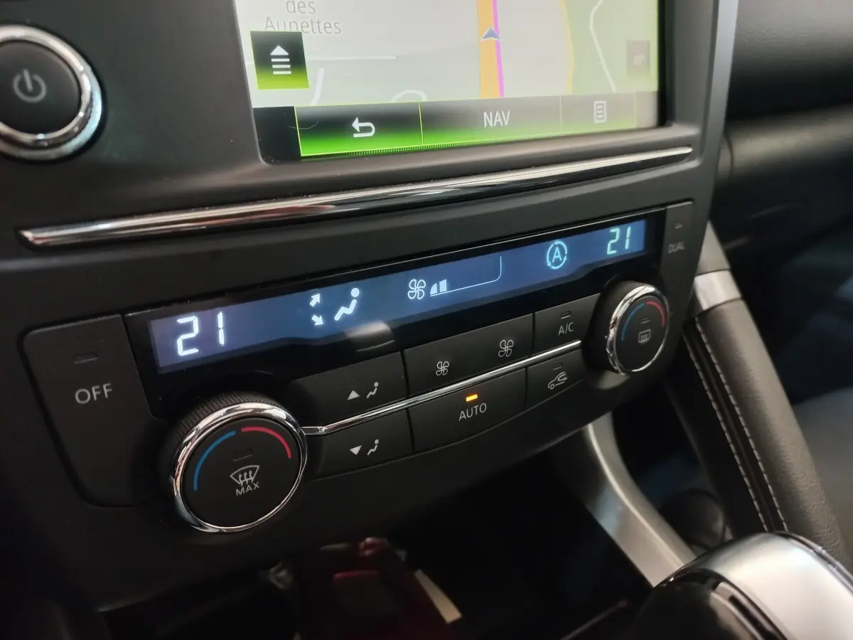 Détail de la console centrale du Renault Kadjar Intens, montrant l'affichage digital de la climatisation bi-zone à 21°C.