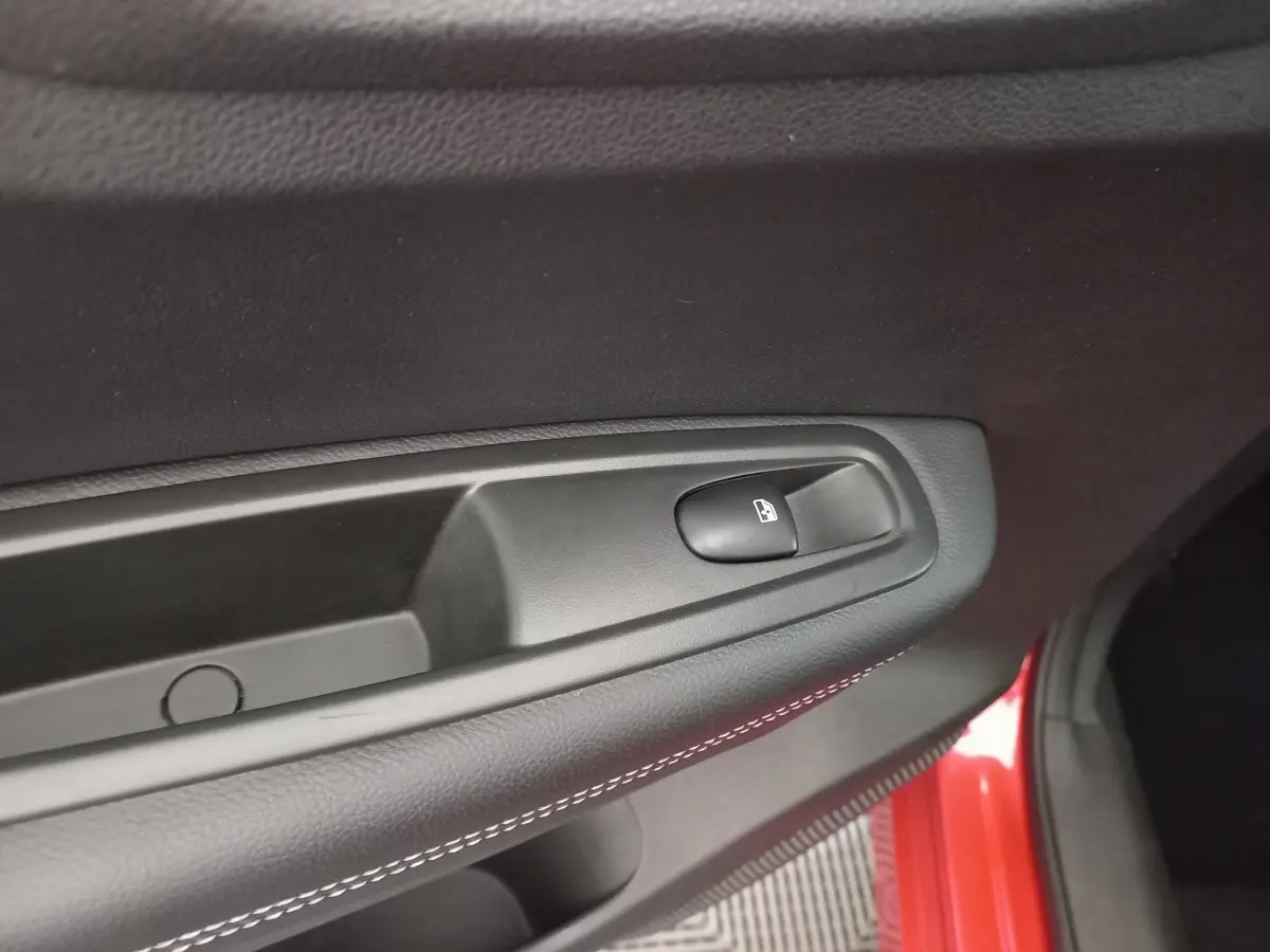 Détail de la commande de verrouillage de porte sur la portière côté conducteur d’un Renault Kadjar rouge.