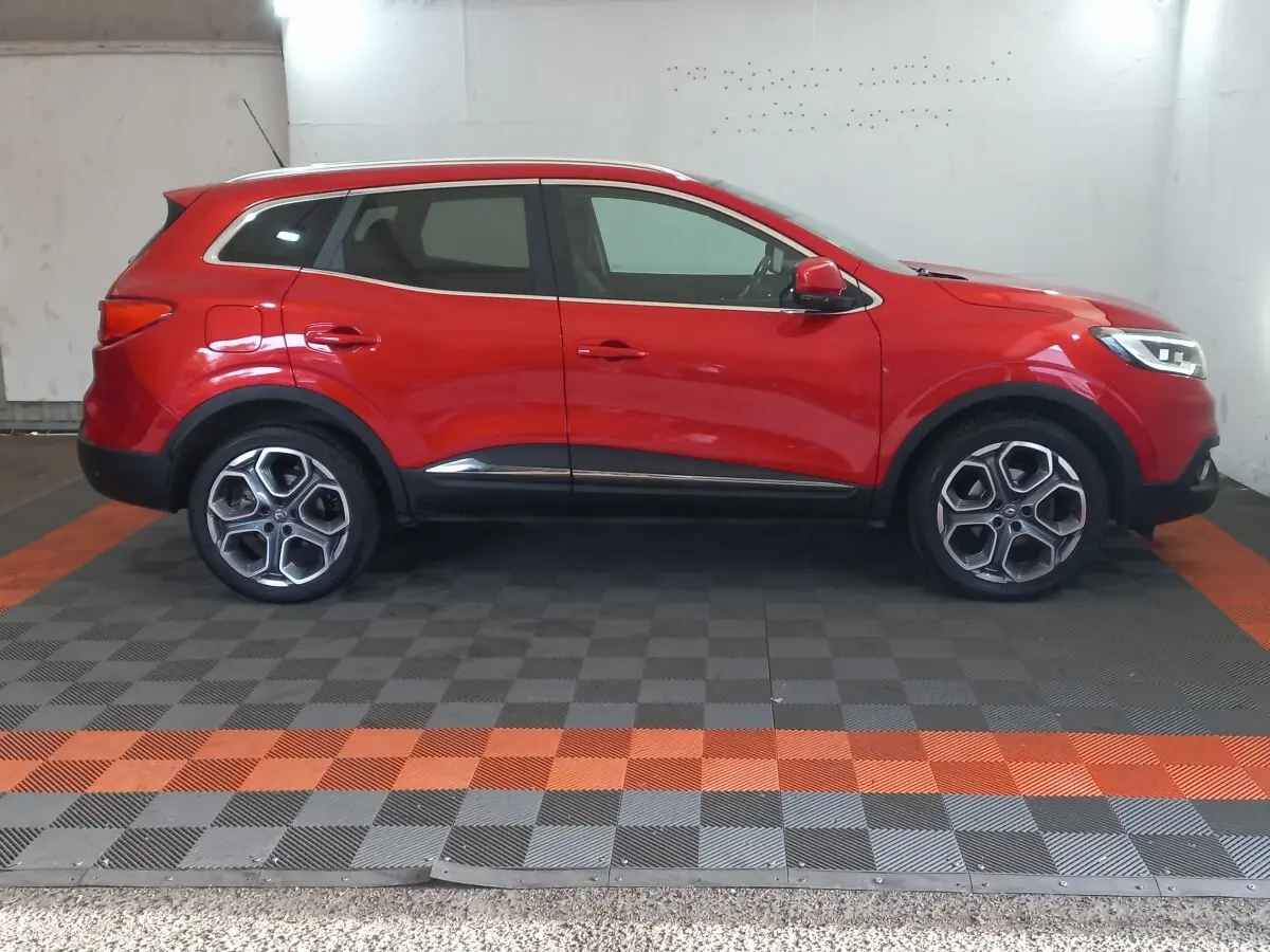 Profil côté gauche d'un Renault Kadjar rouge 2018 avec jantes alliage et détails noirs sur bas de caisse.