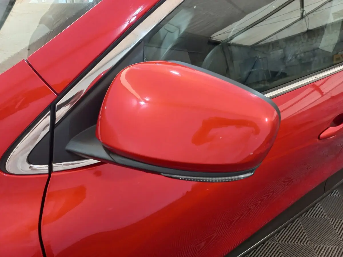 Rétroviseur côté gauche rouge vif du Renault Kadjar Intens Energy TCe 130 EDC, vue rapprochée sur porte et vitre.