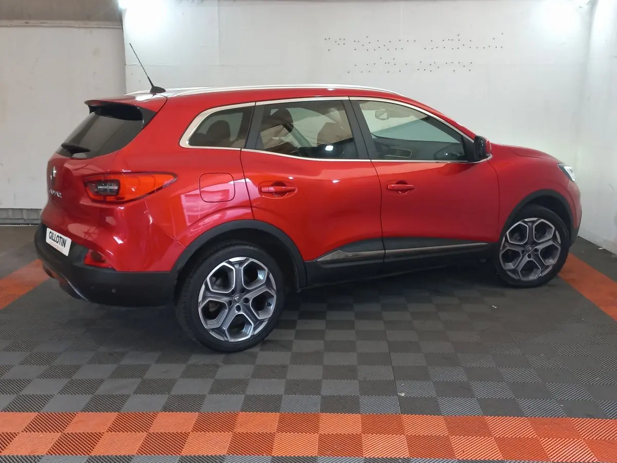 Renault Kadjar Intens rouge vue de profil côté gauche, avec jantes distinctives et protections noires basses.