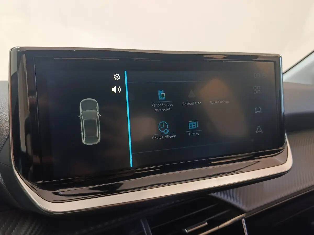 Écran tactile central de la Peugeot 208 électrique 2024 affichant les options de connectivité et charge différée.