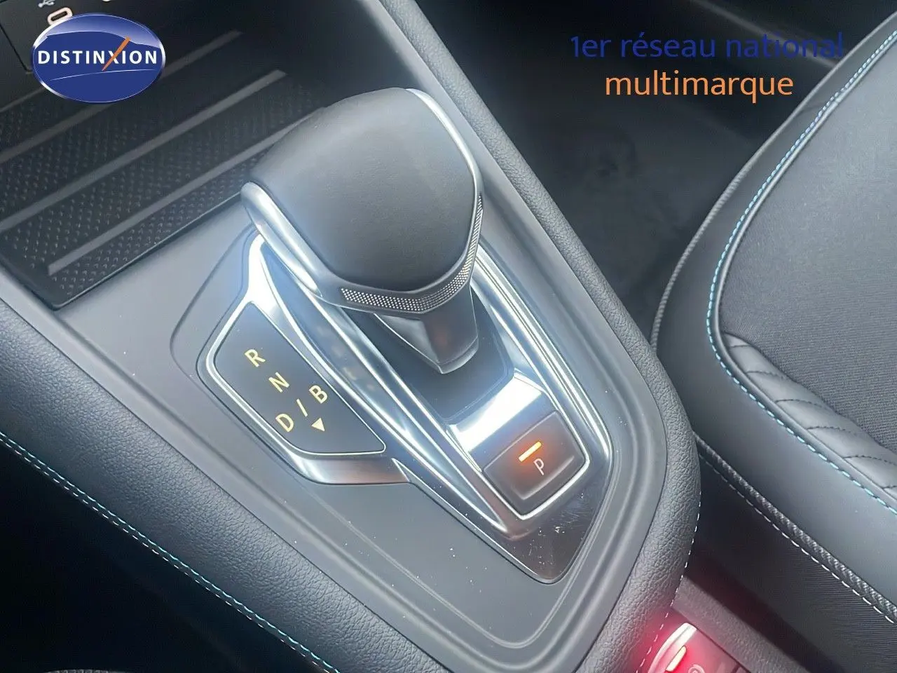 Le levier de vitesses automatique du Renault Captur E-Tech hybride, avec coutures bleues sur sellerie noire.