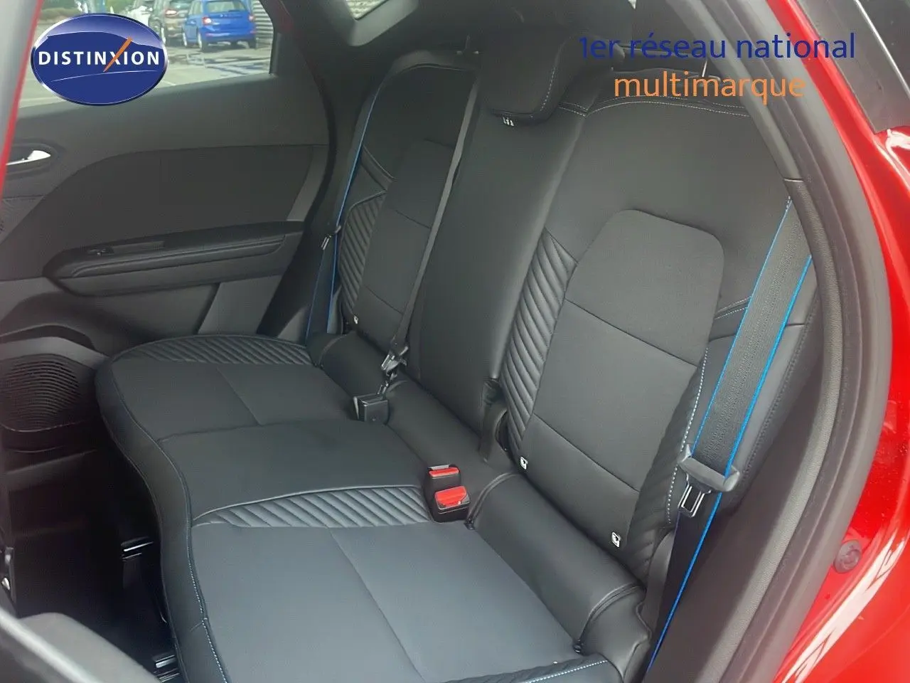 Vue intérieure sur la banquette arrière noire avec surpiqûres bleues du Renault Captur rouge passion toit noir.