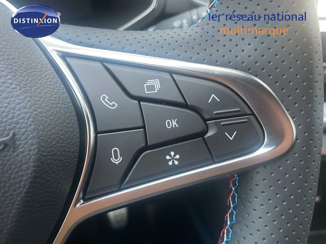 Gros plan sur les commandes multifonctions côté droit du volant perforé du Renault Captur rouge passion toit noir 2025.