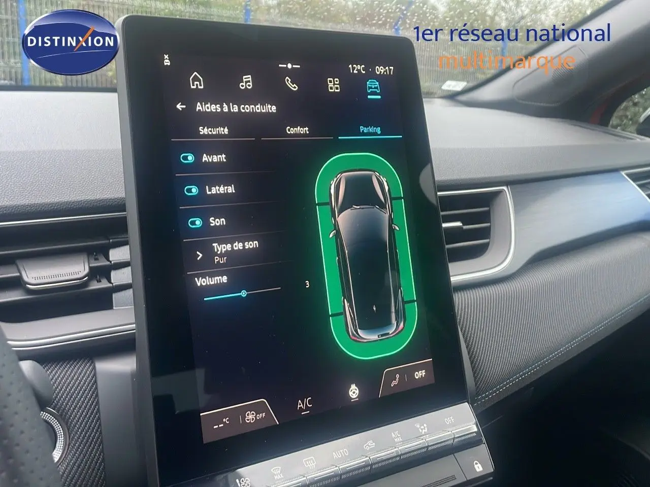 Écran central tactile du Renault Captur E-Tech Hybrid 2025 montrant les aides à la conduite en mode parking, intérieur gris.