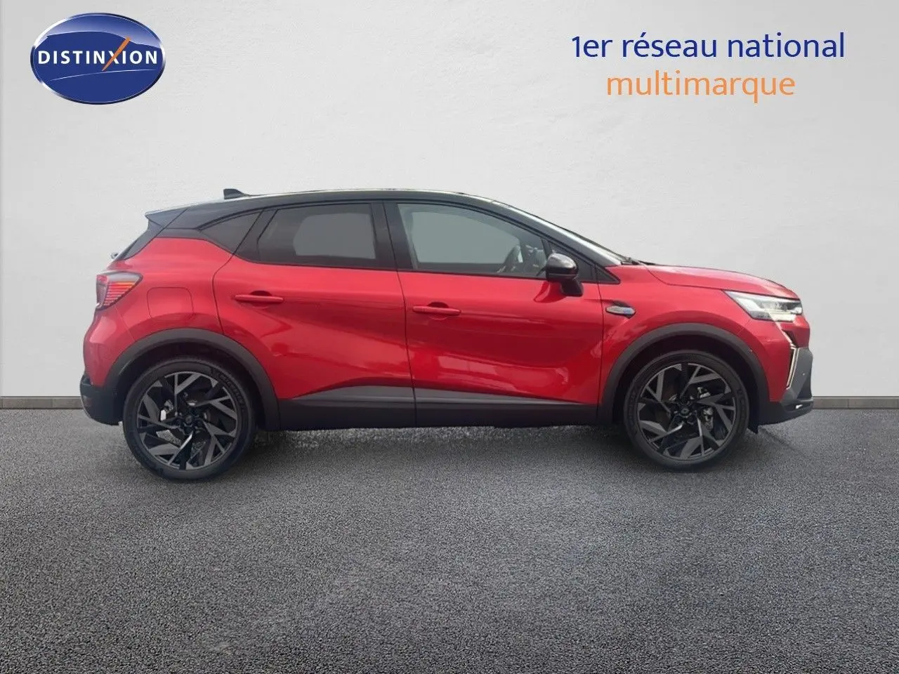 Vue de profil côté gauche du Renault Captur E-Tech hybride rouge passion avec toit noir et jantes noires distinctives.