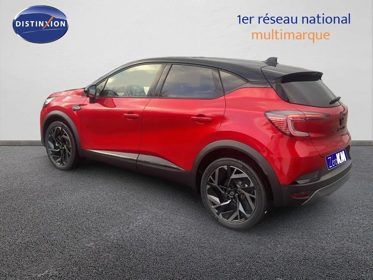 Vue 3/4 arrière droite du Renault Captur E-Tech hybride rouge passion avec toit noir et jantes noires distinctives.