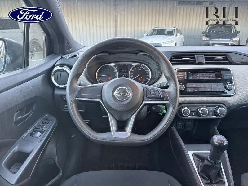 Vue intérieure centrée sur le volant et tableau de bord d'une Nissan Micra 2018 avec boîte manuelle, finition noire.