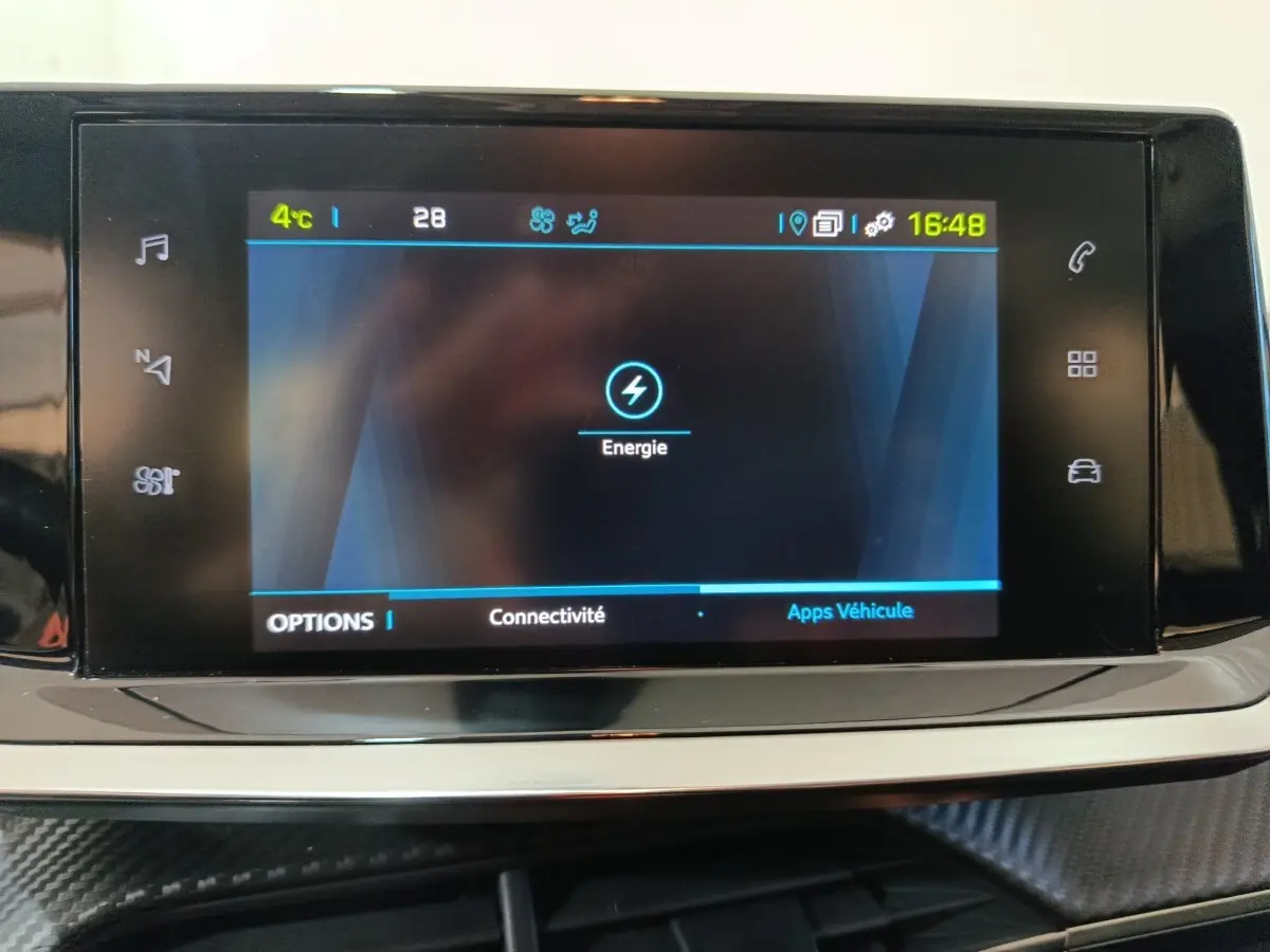 Écran tactile central affichant le menu énergie dans l’habitacle d’une Peugeot 208 électrique blanche.