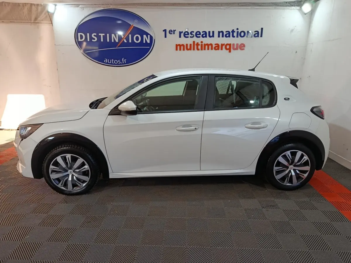 Vue latérale droite d'une Peugeot 208 électrique Active Business blanche, avec jantes distinctives et logo "e" arrière.