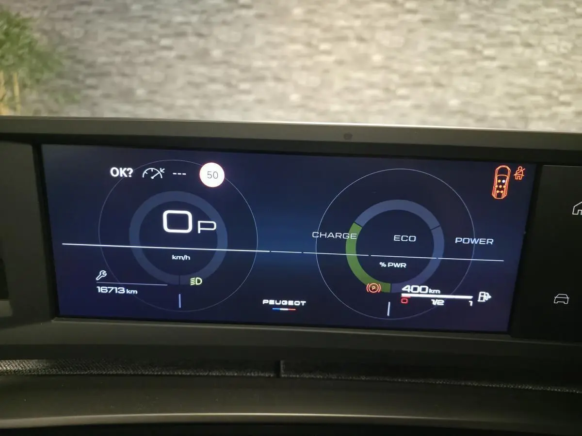Affichage numérique du tableau de bord Peugeot 5008 hybride, avec indicateurs de vitesse, charge et autonomie à 400 km.