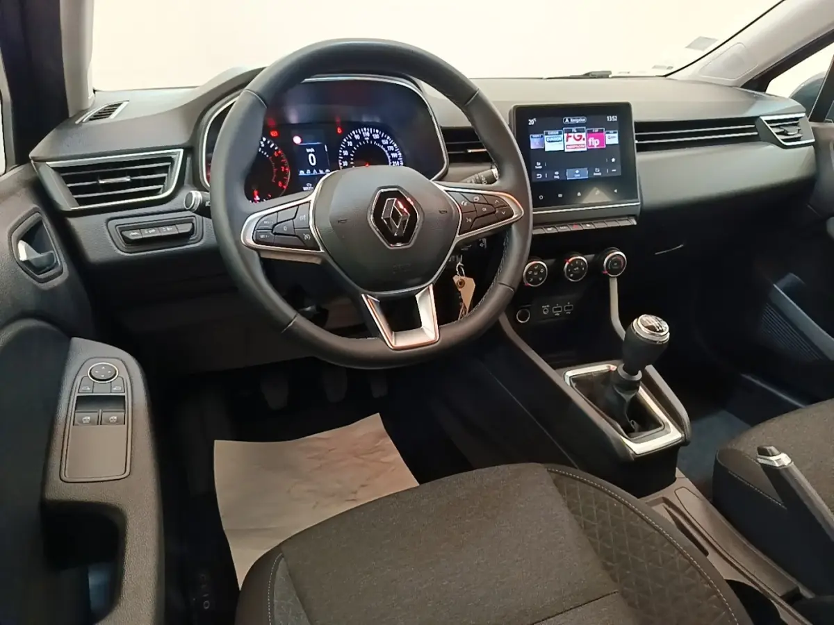 Vue intérieure avant de la Renault Clio Business TCe 100 2021, tableau de bord noir avec écran tactile et volant multifonctions.
