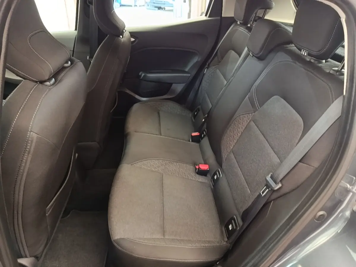 Vue côté gauche des sièges arrière gris foncé en tissu de la Renault Clio Business TCe 100, avec ceintures et appuie-têtes visibles.