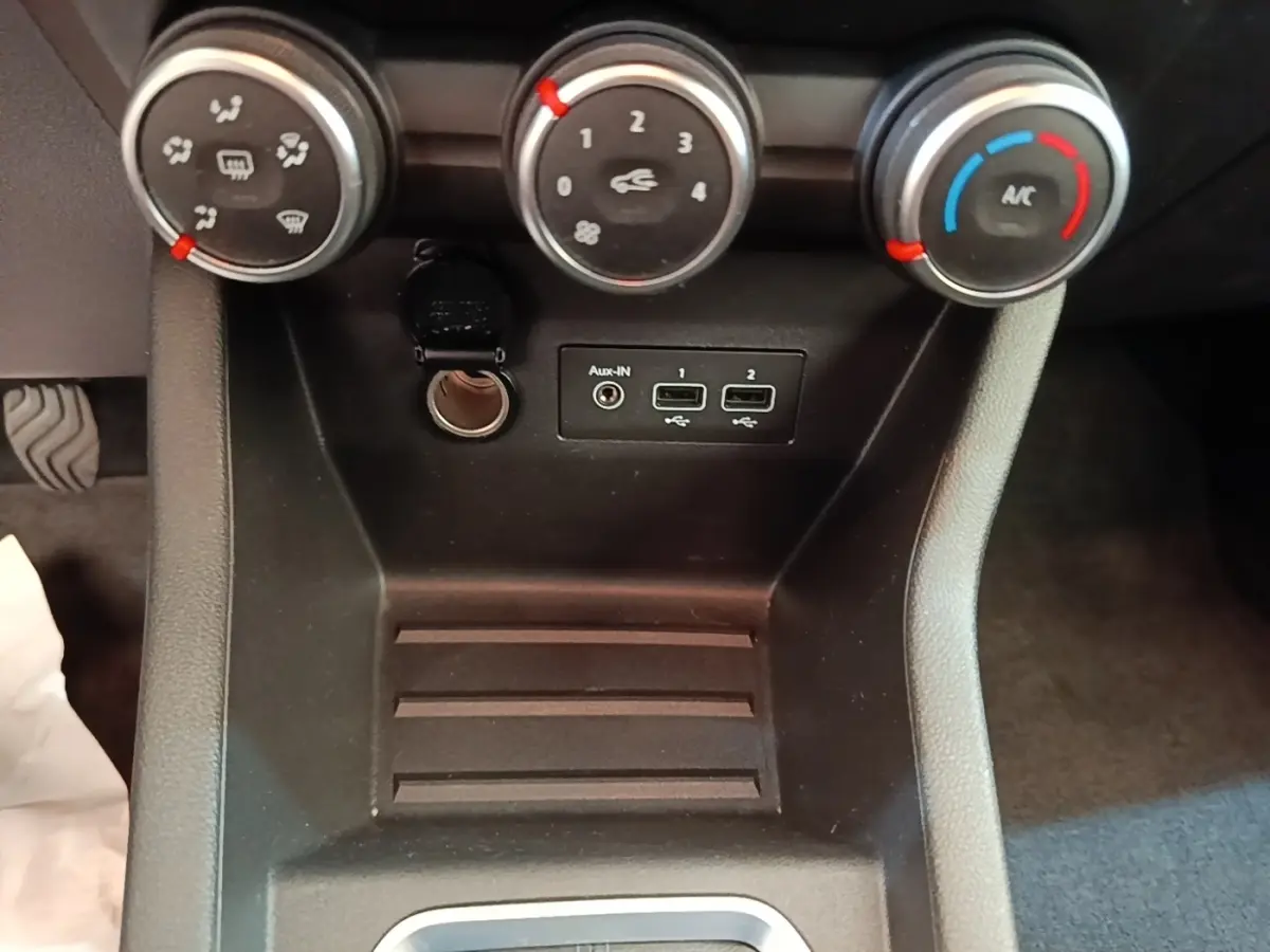 Vue rapprochée du tableau de bord central de la Renault Clio Business TCe 100 2021, montrant les commandes de climatisation et ports USB.