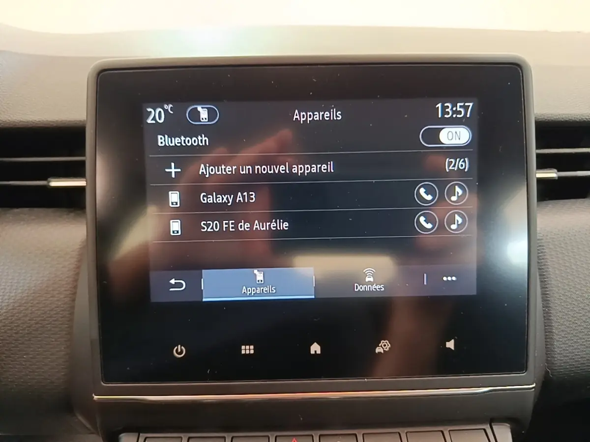 Écran tactile central affichant la connexion Bluetooth dans le tableau de bord d'une Renault Clio Business gris foncé.