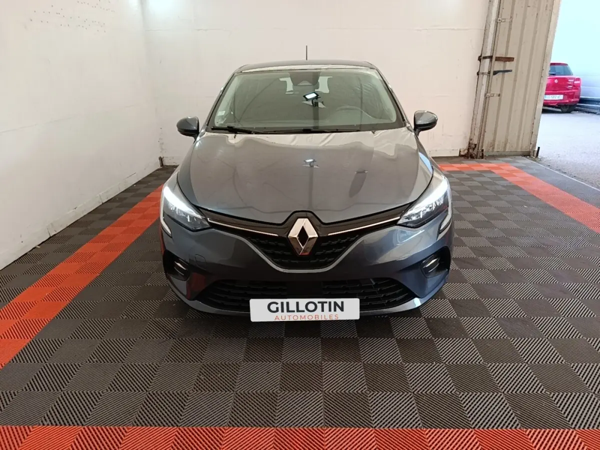 Renault Clio Business TCe 100 gris foncé vue de face, phares LED allumés dans un garage.
